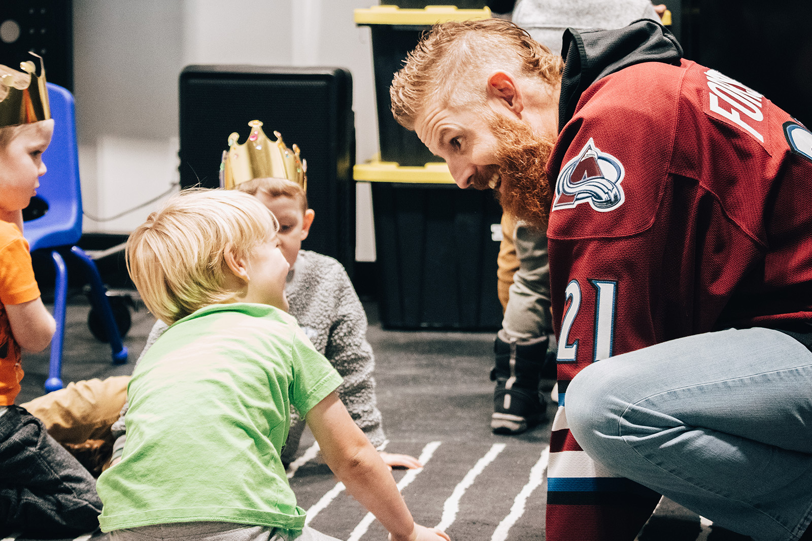 Man kneeling down beside a happy little boy