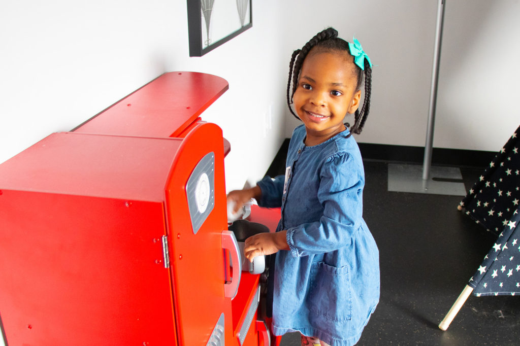 Little African Girl playing at a toy kitchen