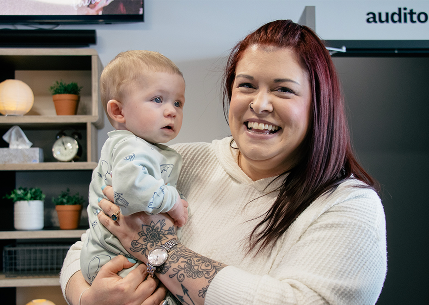 Smiling woman, holding a baby